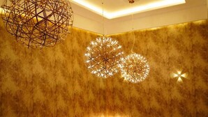 Um interior moderno com lustres geométricos e parede texturizada.