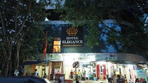 Um hotel chamado "Hotel Elegance" com uma placa indicando serviços de hospedagem.