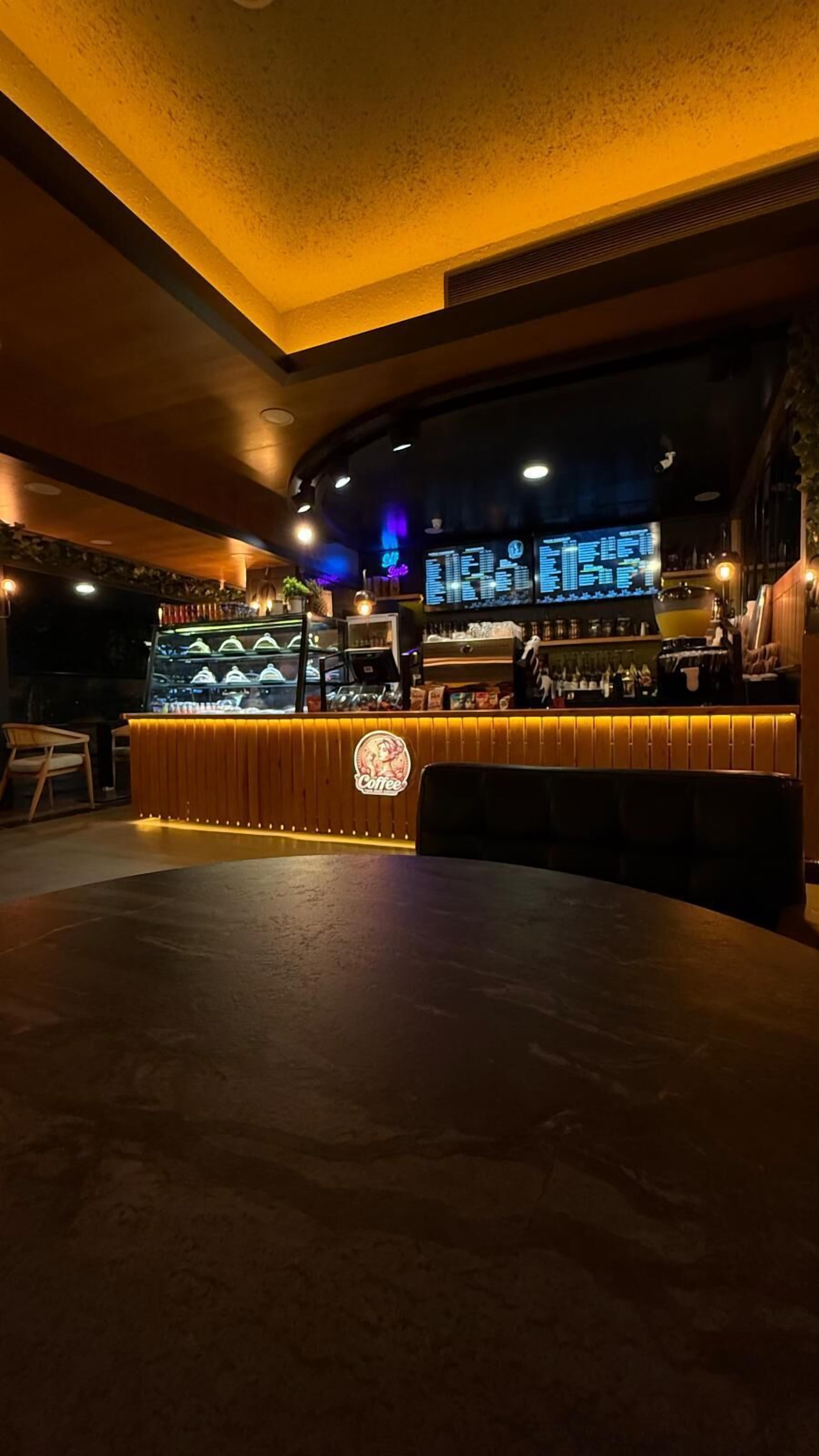 A bar area with a counter, seating, and a menu display.