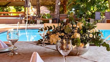 Una piscina al aire libre, sombrillas, sillones reclinables de piscina