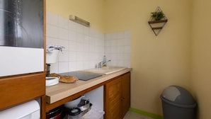 Eine kleine Küche mit Spüle, Arbeitsplatte und Schränken.