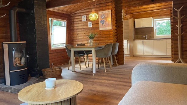A cozy cabin interior with a dining area, a fireplace, and a kitchen. - Nideggen's Schwedenhaus, right next to the forest with great hiking trails and a fireplace. (Nideggen)