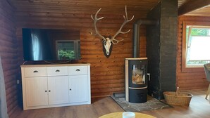 A cozy cabin interior with a wooden ceiling, a stone fireplace, a television, and a cabinet. - Nideggen's Schwedenhaus, right next to the forest with great hiking trails and a fireplace. (Nideggen)