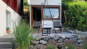 A modern house with a stone wall and outdoor seating area. - Nideggen's Schwedenhaus, right next to the forest with great hiking trails and a fireplace. (Nideggen)