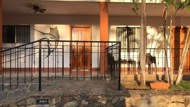 A stone-paved entrance with a metal railing, a wooden door, and a ceiling fan. - Bolimar Collection at Playa Hermosa - N4 (Playa Hermosa)