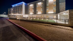 Un hôtel moderne avec une enseigne indiquant « EVERYHOME SUITES » et une façade bien éclairée.
