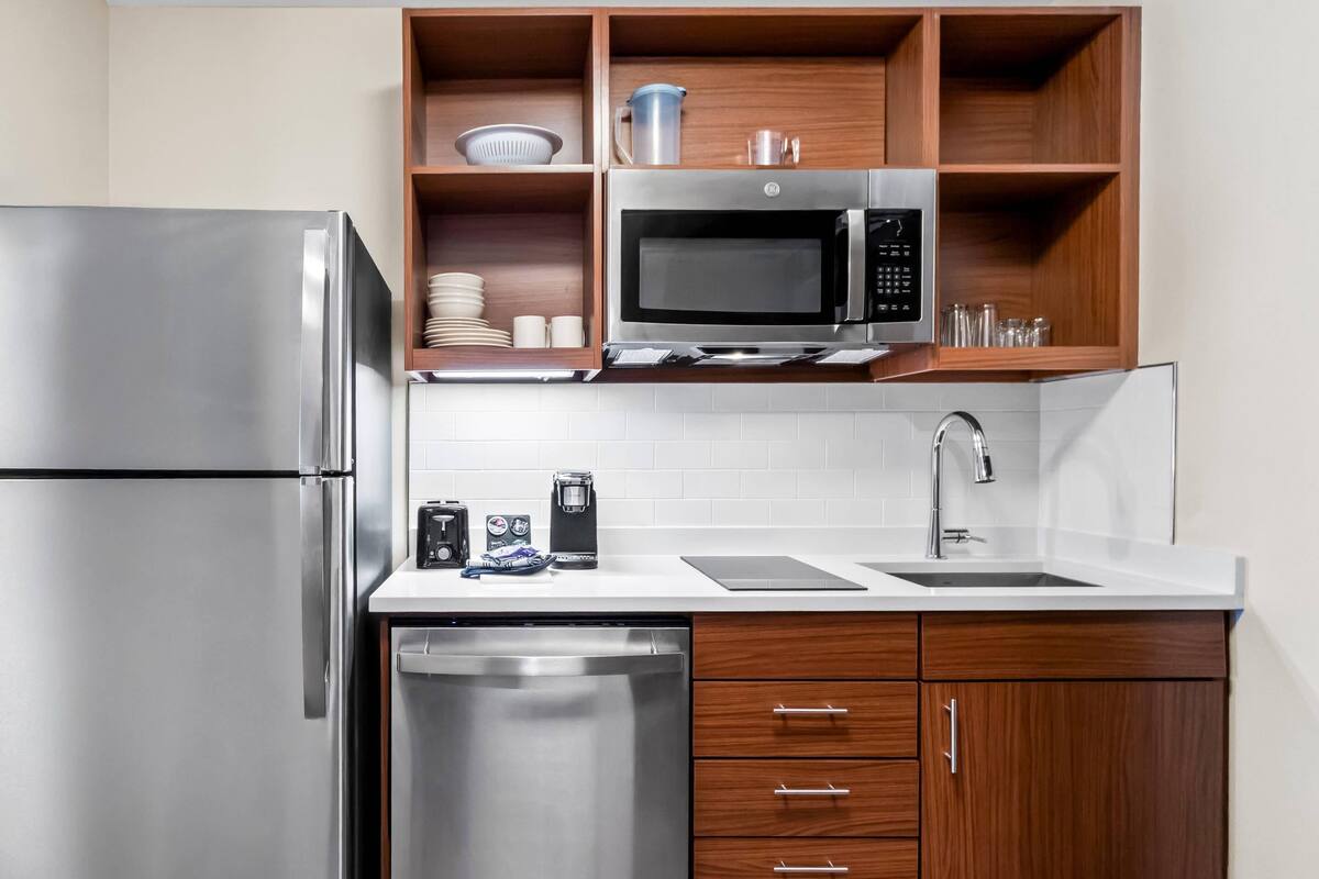 A modern kitchen with a stainless steel refrigerator, a microwave, and a dishwasher.