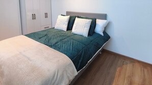 Une chambre à coucher avec un lit, une armoire et un luminaire au plafond.