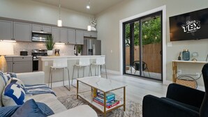 Un salon moderne avec un canapé, une table basse et un téléviseur fixé au mur.