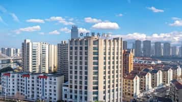 A high-rise building with multiple floors, surrounded by other buildings, under a clear sky.