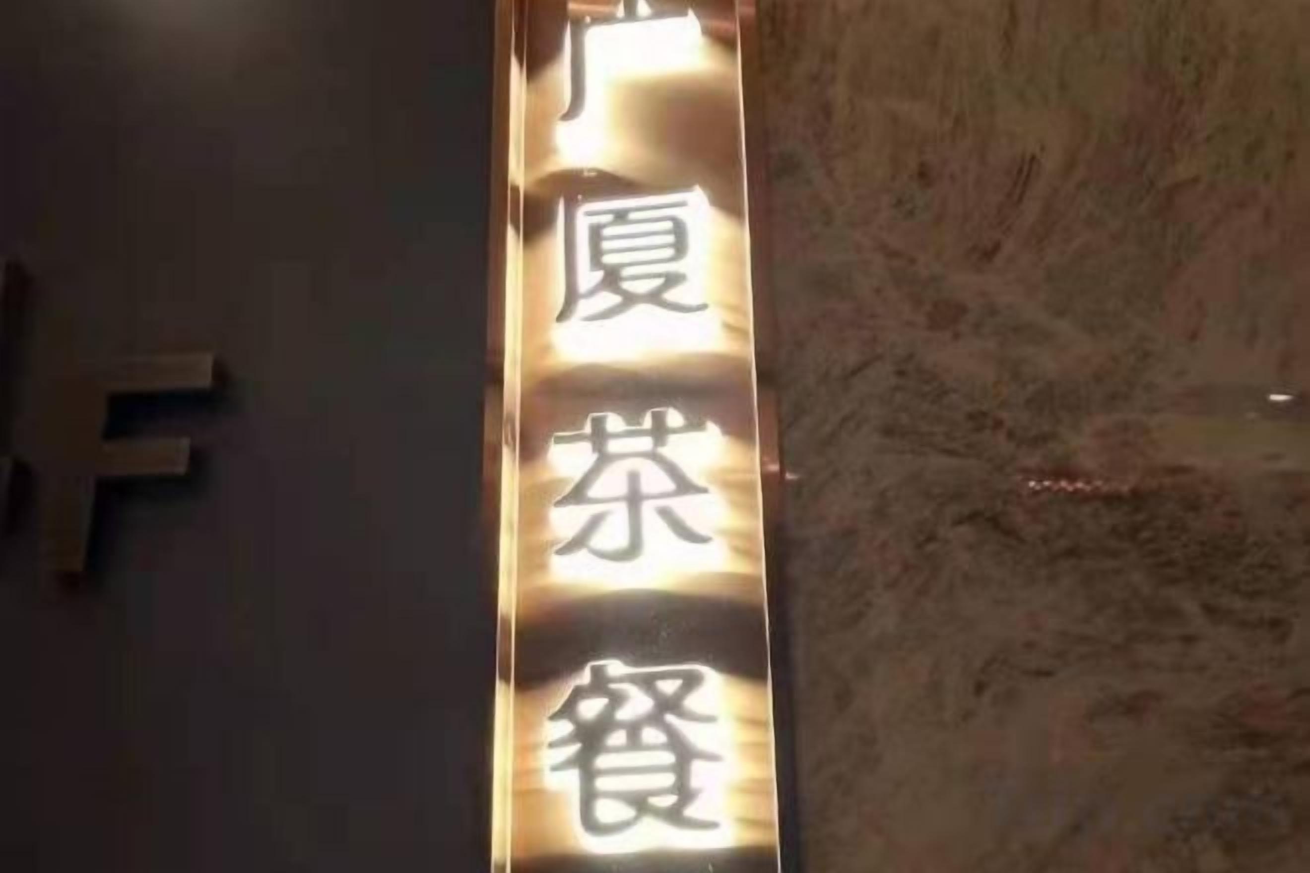 A vertical sign with Chinese characters, likely indicating a hotel or establishment name.