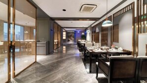 A modern hotel lobby with a long corridor, a reception desk, and a dining area with tables and chairs. - Guangsha Hotel (Shengzhou)