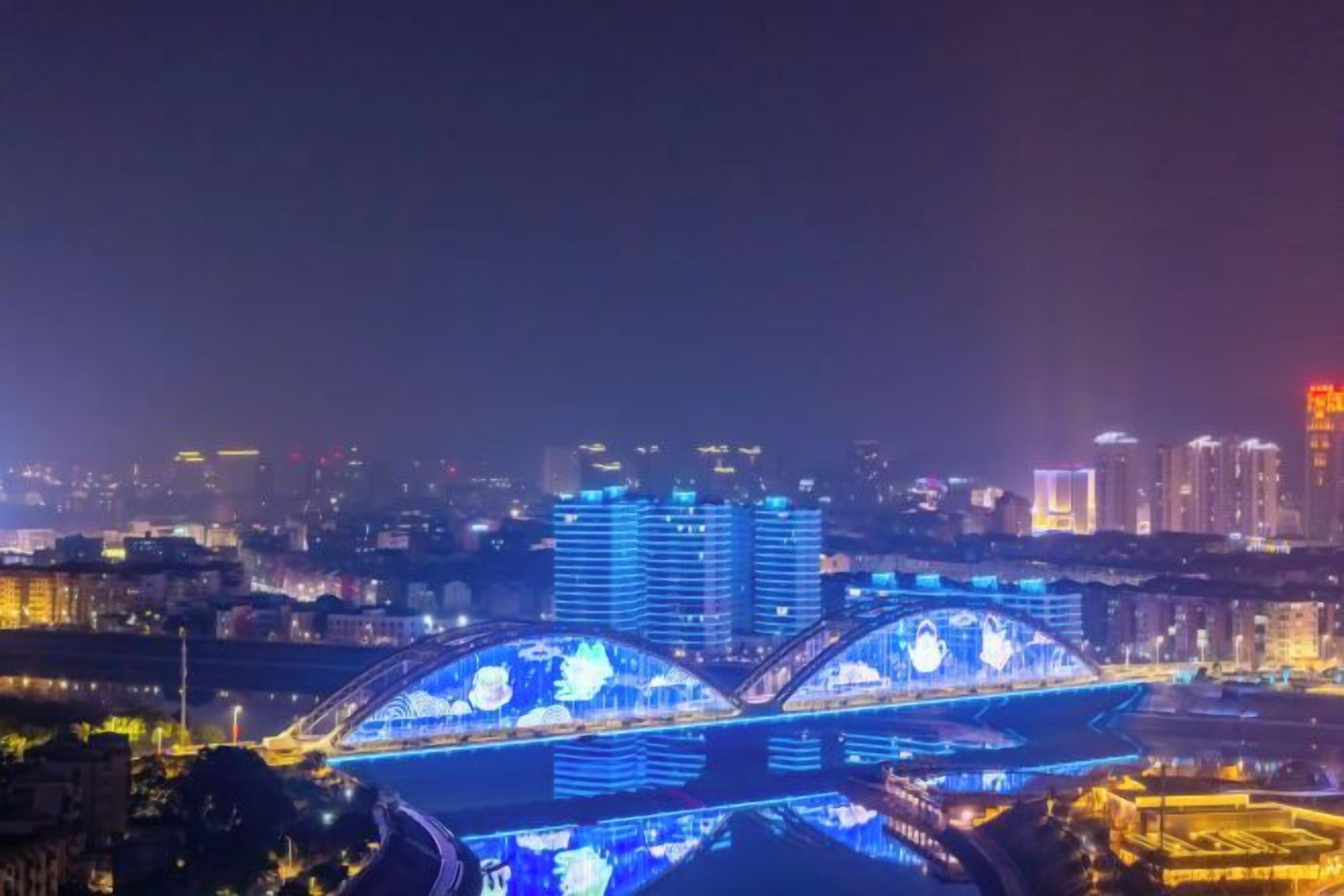 Un paisaje urbano nocturno con puentes e edificios iluminados.