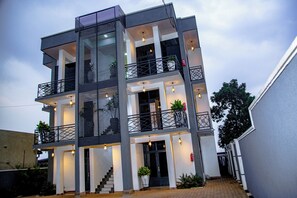 A multi-story building with balconies, staircases, and outdoor lighting. - Apartment - Sleeps 4 - Parking - Balcony (Kigali)
