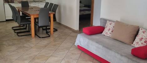 Um espaço de estar compacto com área de jantar e sofá.
