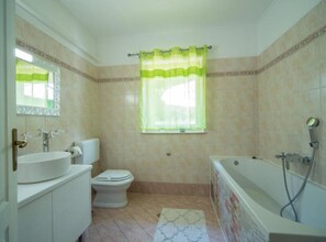 A bathroom with a toilet, sink, and bathtub.