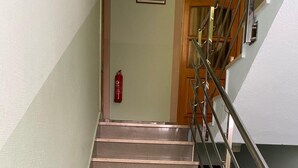 A staircase with a fire extinguisher mounted on the wall and a door at the top.