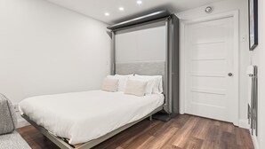 A modern bedroom with a bed, a sliding door, and a white wall. - Dog-Friendly Apt w/ EV Charger / Walk to Aspen (Aspen)