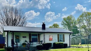 A single-story house with a front porch, a chimney, and a well-maintained lawn. - The Gatehouse, 2-bedroom house in charming Gamaliel with WiFi, AC, pet friendly. (Gamaliel)