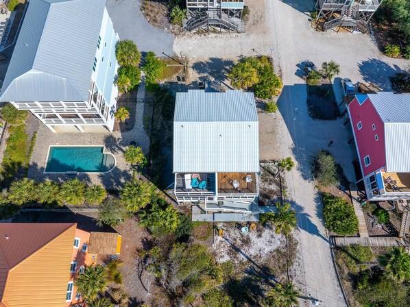 An aerial view of a coastal property with a swimming pool, a wooden deck, and a red building. - Casita Azul (Port St. Joe)