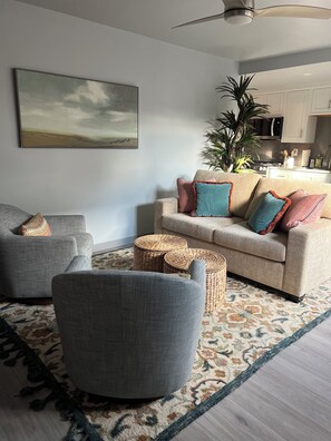 A living room with a sofa, armchairs, a coffee table, a patterned rug, and a painting on the wall. - Charming 1-bedroom townhome in brilliant Hermosa Beach (Hermosa Beach)