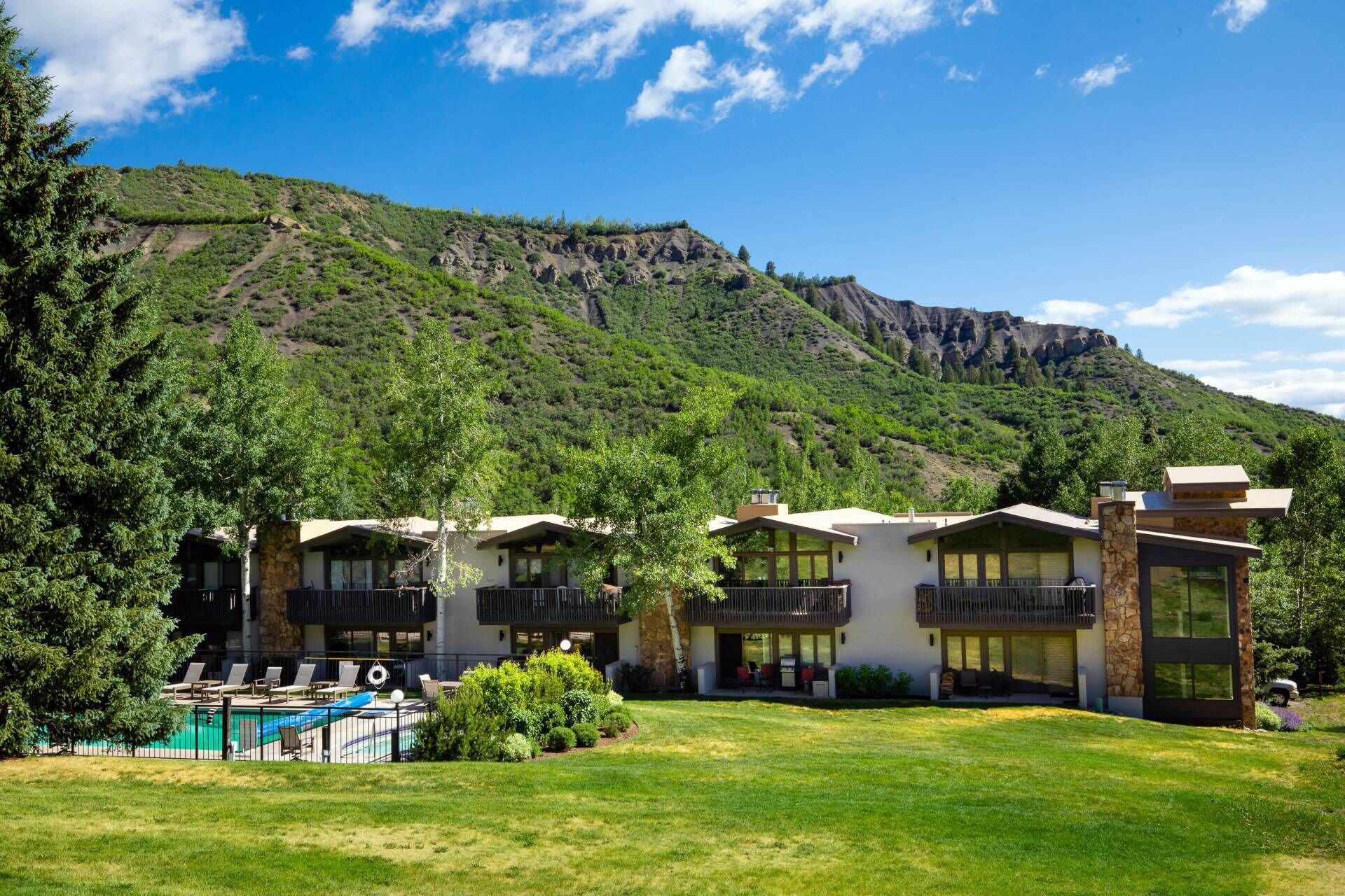 Un hôtel composé de plusieurs bâtiments, doté d’une piscine et situé dans un cadre montagneux.