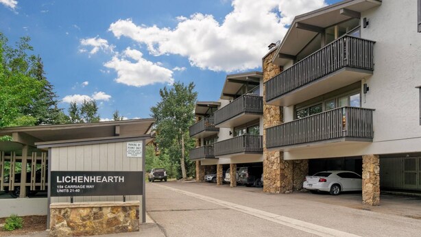 A modern multi-story building with balconies, a sign indicating parking by permit only, and a sign for Lichenhearth units 21-40. - Lichenhearth 29 (Snowmass Village)