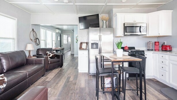 A modern kitchen with white cabinets, a stainless steel refrigerator, a microwave, and a red toaster. - The Horseshoe Hideaway - Rodeo Themed & 1/2 mile walk to Whiskey Row! (Prescott)