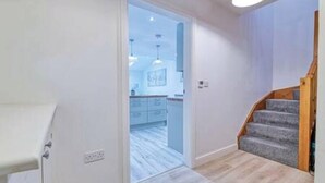 A modern interior with a staircase leading to a kitchen area. - Middlecroft Annex by Guestz (Sutton)