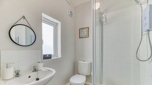 A bathroom with a sink, toilet, and shower.