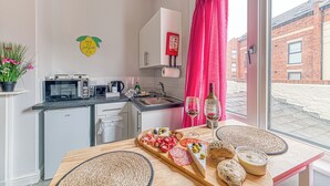 Eine moderne Küche mit Essbereich, Blick auf die Straße und einem an der Wand befestigten Feuerlöscher.