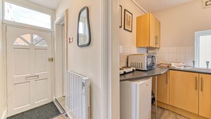 A kitchen with wooden cabinets, a microwave, and a refrigerator. - Chester Heights by Guestz (Chester)
