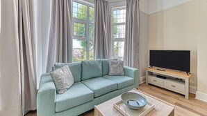 A living room with a sofa, a TV, and a coffee table. - Chester Heights by Guestz (Chester)