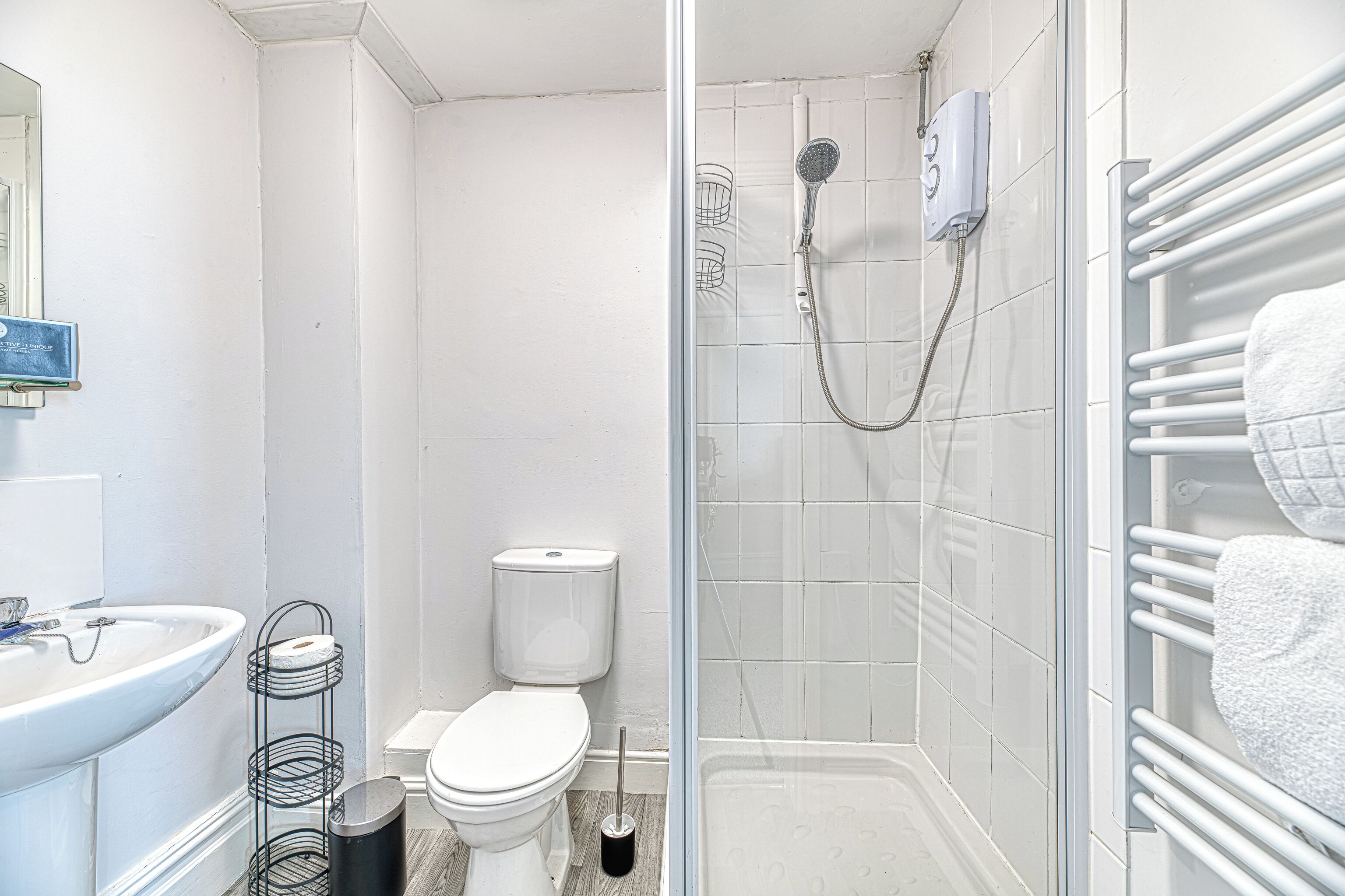 Un bagno con servizi igienici, lavandino, doccia e porta asciugamani.