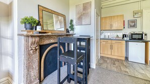 A kitchen with a built-in microwave, a coffee maker, and a small refrigerator. - Chester Heights by Guestz (Chester)