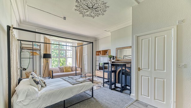 A bedroom with a four-poster bed, a sofa, a desk, and a chair. - Chester Heights by Guestz (Chester)