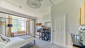 A bedroom with a large bed, a desk, and a view of the outdoors. - Chester Heights by Guestz (Chester)