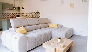 Una sala moderna con un sofá gris, dos almohadas amarillas y una mesa de centro de madera.