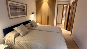 Quarto com cama grande, mesa de cabeceira, ventilador de teto e quadro na parede.