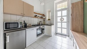 A modern kitchen with white cabinets, a microwave, a stove, and a sink.