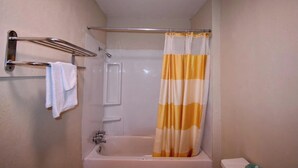 Baño con bañera, ducha, toallero y cortina.