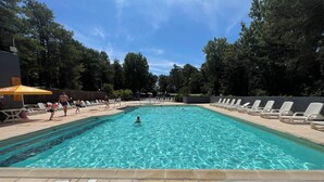 A rectangular swimming pool with clear blue water, surrounded by lounge chairs and a tiled deck. - 3-bedroom mobile home with pool (Camiers)