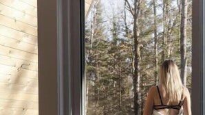 A wooden interior with a large window, a wooden table, and a chair. - Prunella № 1, Prunella № 1 - A-Frame Cabin Getaway - Design, Comfort & Nature (Thorne)