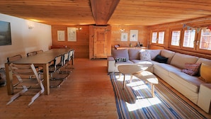 A wooden interior with a dining table, chairs, a sofa, and a coffee table. - Chalet Berthé 11 (Les Haudères)