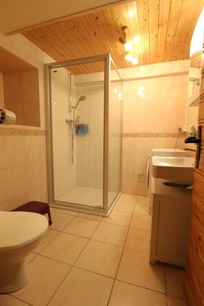 A bathroom with a shower, toilet, and sink.