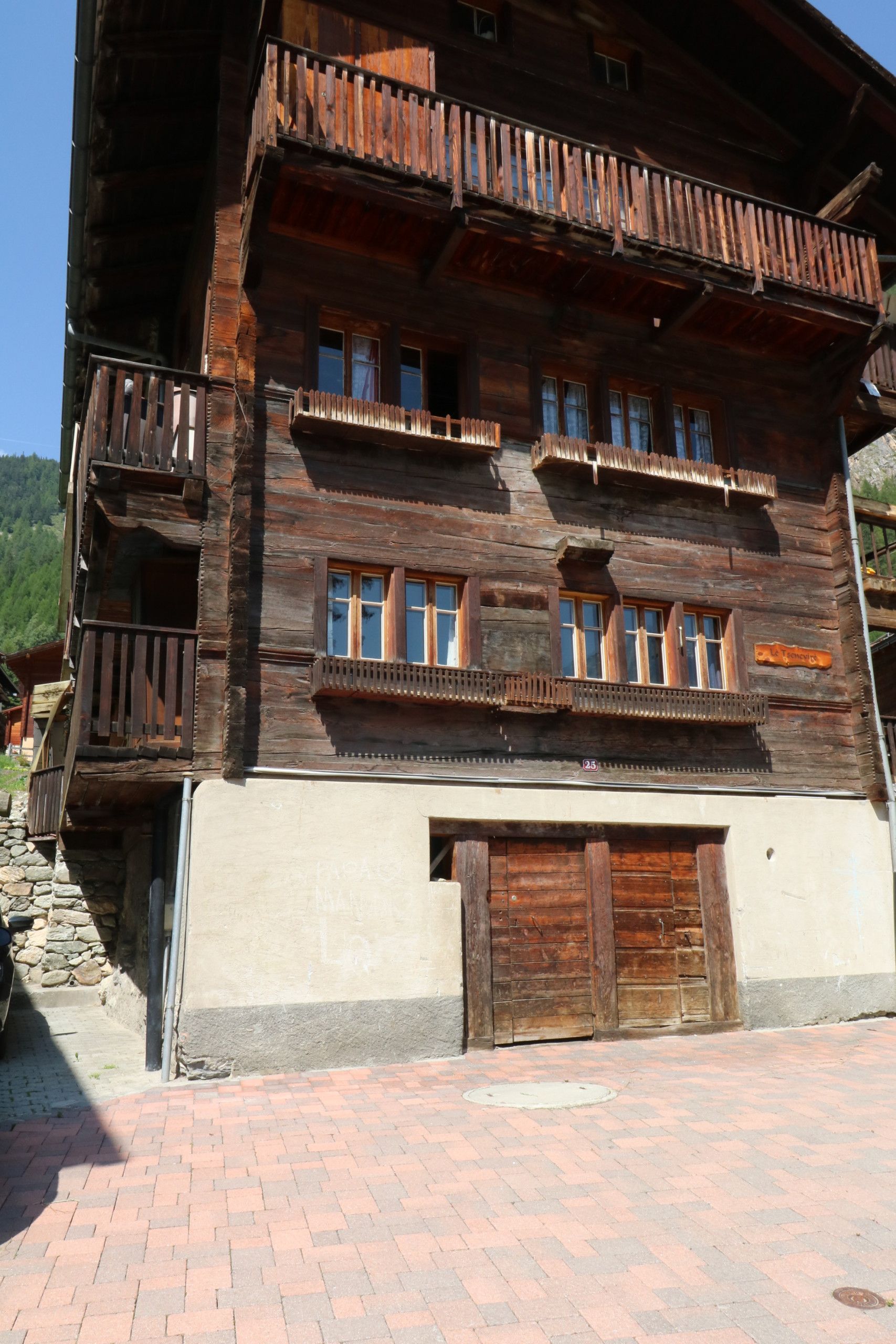 Ein mehrstöckiges Holzhaus mit Balkonen, großen Fenstern und einem Steinfundament.