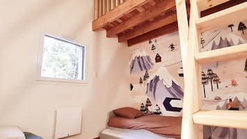 Quarto com beliche, janela e parede com mural de tema montanhista.
