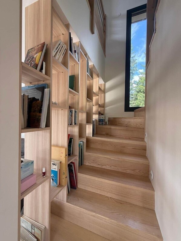 A staircase with wooden steps and built-in bookshelves on either side. - Le Perchoir de l'Olme (Chalmazel-Jeansagniere)