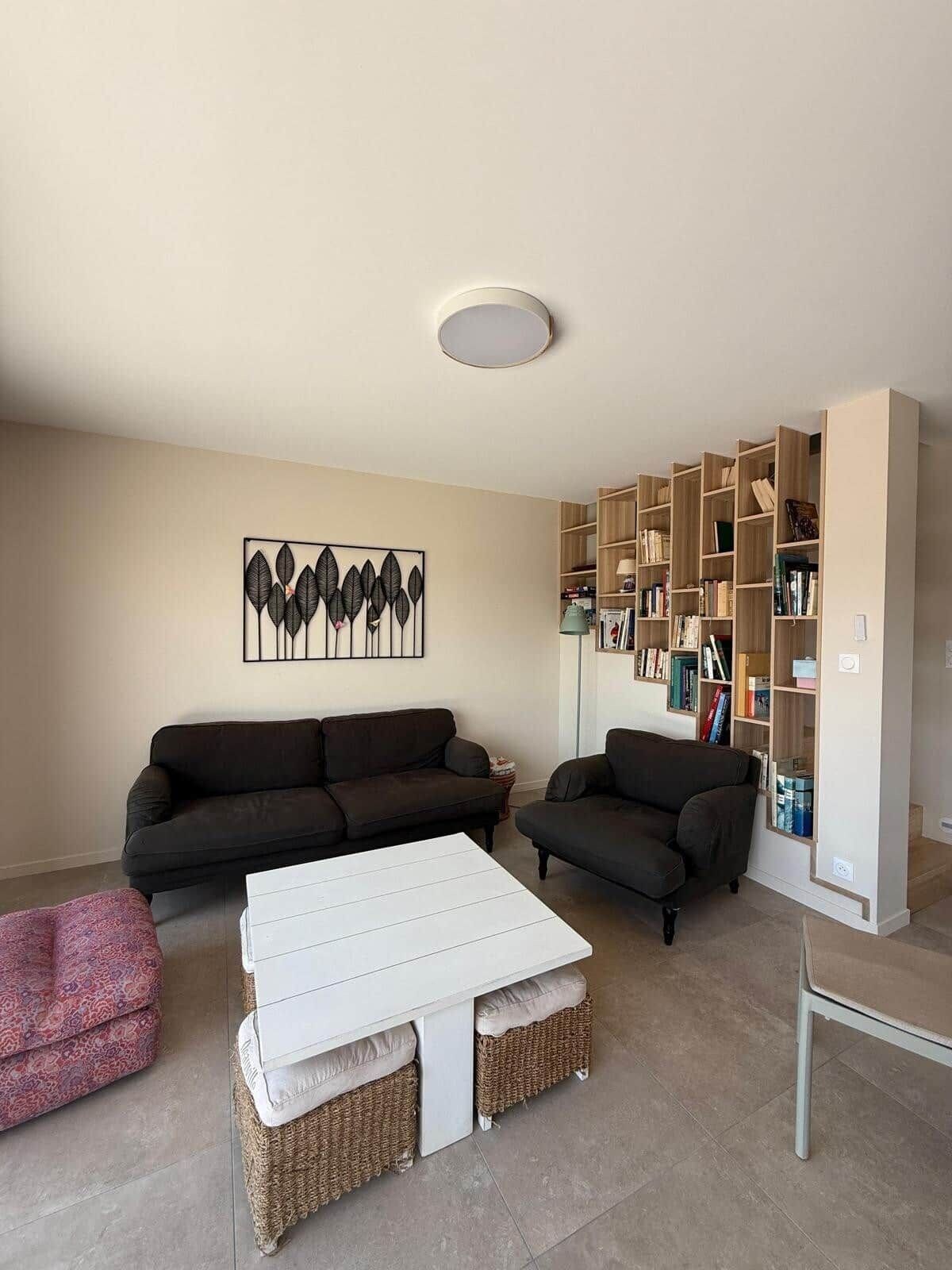 A living room with two sofas, a white coffee table, and a bookshelf.