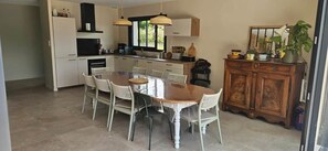 Una cocina moderna con una mesa de comedor, sillas y un armario de madera.